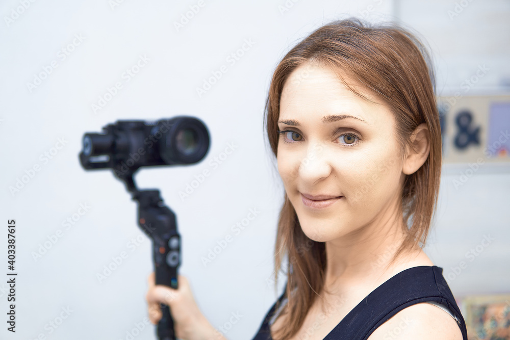 beautiful woman sitting at home recording a blog for video media platforms with mirrorless camera and gimbal. blogger blog concept. beautiful woman sitting at home recording a blog for video media platforms with mirrorless camera and gimbal. blogger blog concept.