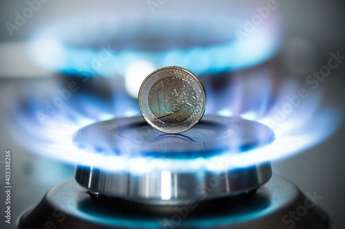Burning natural gas and one euro coin on gas hob. photo
