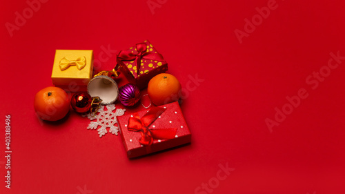 Top view flat lay image colorful boxes gifts presents bright design isolated on red background. Fresh mandarin oranges juicy tangerines, calamondine fruits citrus ripe photo