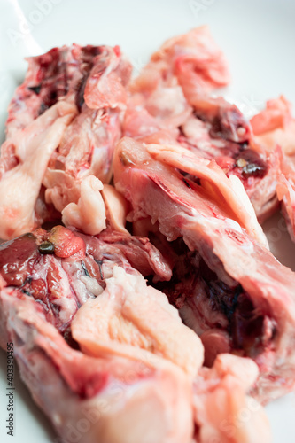 Raw uncooked chicken backs with skin and bone isolated on white close up shot