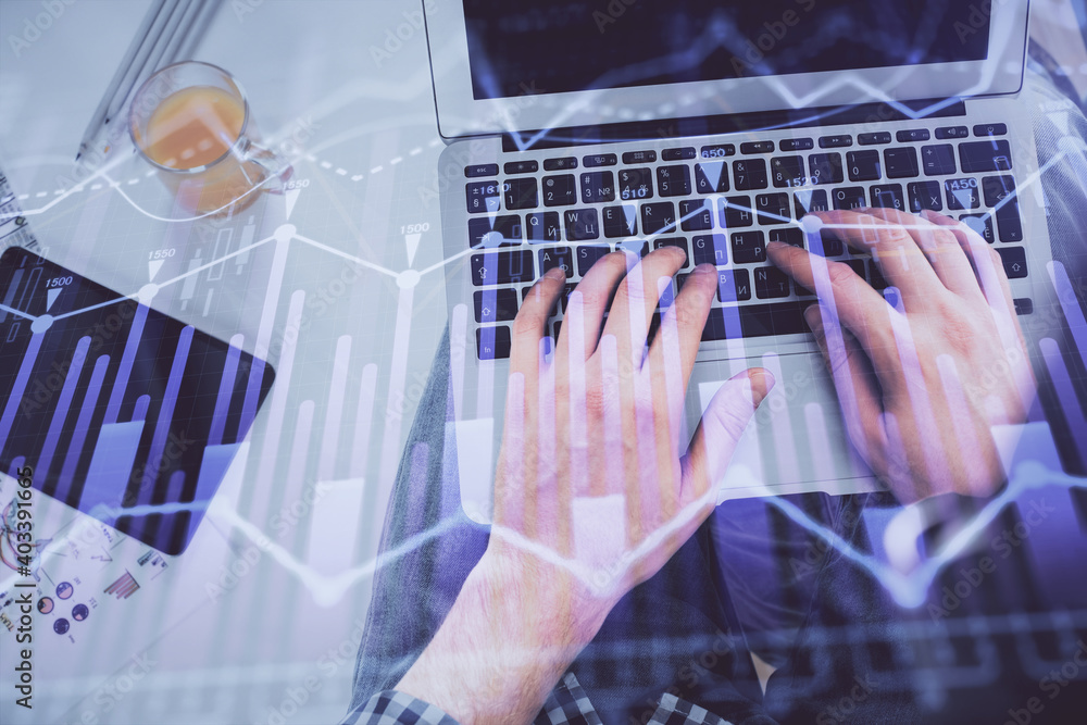 Double exposure of man's hands typing over laptop keyboard and forex chart hologram drawing. Top view. Financial markets concept. Double exposure of man's hands typing over laptop keyboard and forex chart hologram drawing. Top view. Financial markets concept.