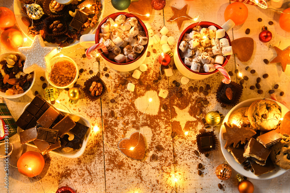 sweet food top view background for merry christmas or new year holiday decoration with night illumination - chocolate candies, tangerines, cookies, marshmallow and cocoa latte on white wood sweet food top view background for merry christmas or new year holiday decoration with night illumination - chocolate candies, tangerines, cookies, marshmallow and cocoa latte on white wood