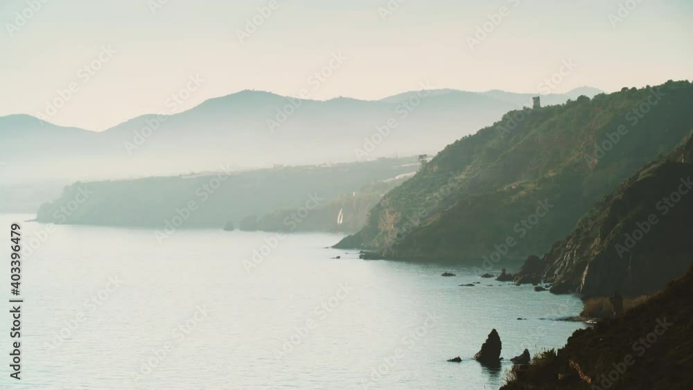 Coastal landscape on overcast day. Cliffs of Maro Cerro Gordo Natural Park with Maro tower, Malaga province, Costa Del Sol, Andalusia, Spain. Time lapse Coastal landscape on overcast day. Cliffs of Maro Cerro Gordo Natural Park with Maro tower, Malaga province, Costa Del Sol, Andalusia, Spain. Time lapse