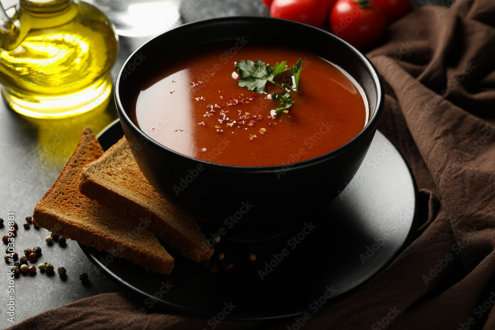 Concept of tasty food with tomato soup on black smokey background Concept of tasty food with tomato soup on black smokey background
