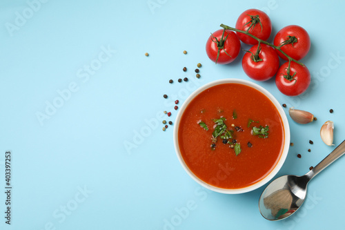Obraz na plátně Bowl with tomato soup and ingredients on blue background