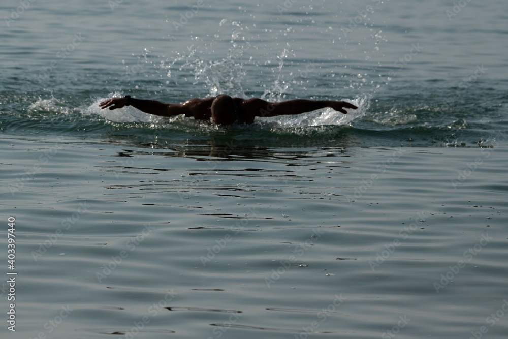 Obraz premium man swimming in the sea towards the camera