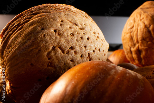 Extreme closeup of an almonds exterior shell in a bowl of other types of nuts