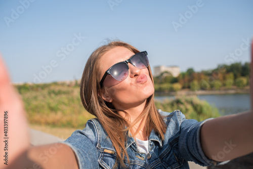 Pretty blonde girl makes selfie. Shows a kiss