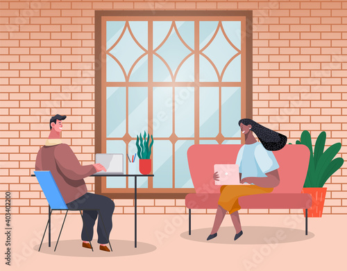 Business people man and woman are sitting at the table typing on laptops and talking in modern interior with brick wall. Office workers discussing matters. Business meeting and consideration