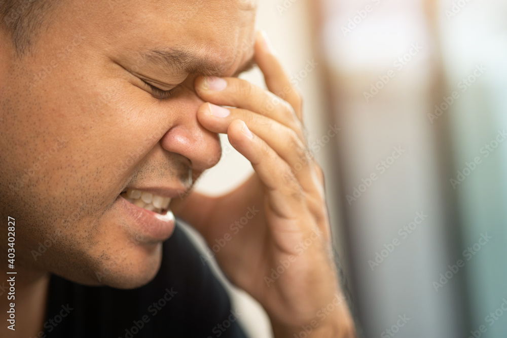 Young asian man hand in head he's feeling depressed, stress, headache be tired from working long time he symptom office syndrome. Young asian man hand in head he's feeling depressed, stress, headache be tired from working long time he symptom office syndrome.