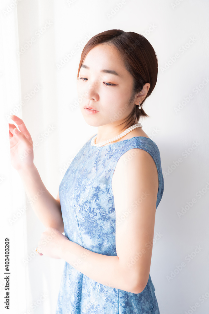 窓の前に立つドレスを着た女性
窓の前に立つドレスを着た女性