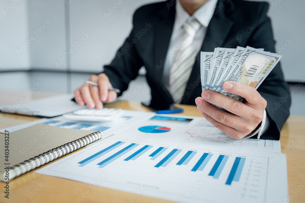 Close up of Serious man hand checking bills and counting money at work from home office Close up of Serious man hand checking bills and counting money at work from home office