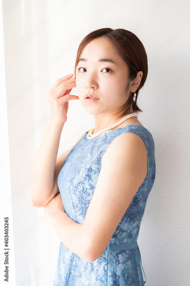 窓の前に立つドレスを着た女性
