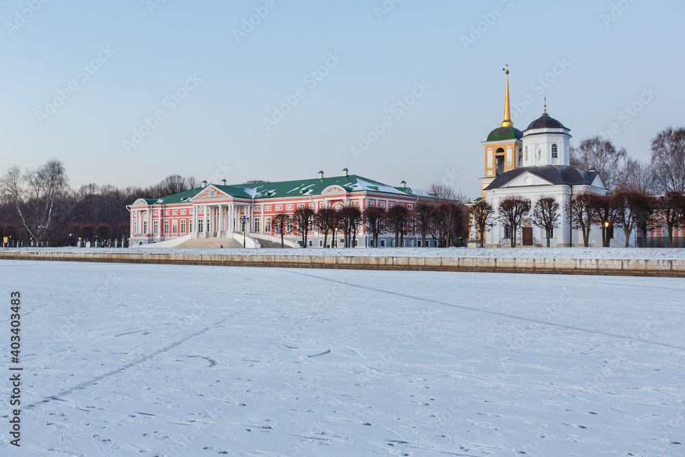 Kuskovo palace and park in winter. Count Sheremetev's Manor house, Сhurch of the Savior and bell tower at the lake shore. Beautiful architectural ensemble of XVIII century. Moscow, Russia