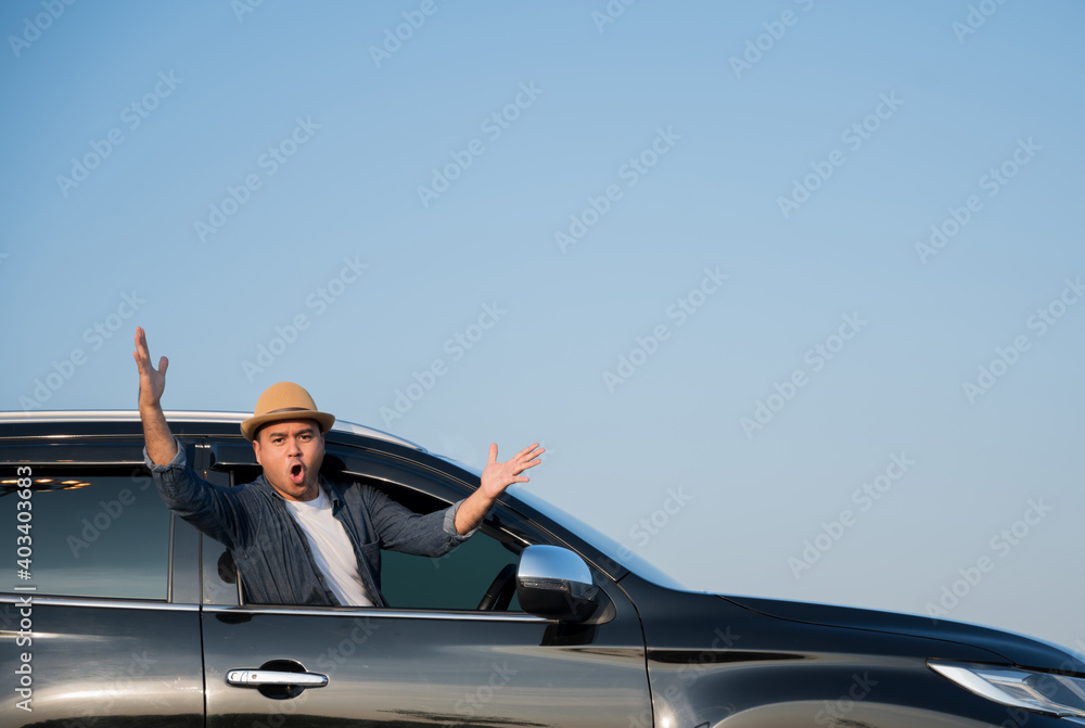 A young Asian man drives a car on a clear day. With beautiful blue sky. He driving to travel by car. A young Asian man drives a car on a clear day. With beautiful blue sky. He driving to travel by car.