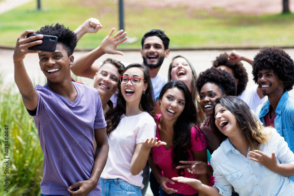 Fototapeta premium Large group of multi ethnic young adults taking crazy selfie with phone