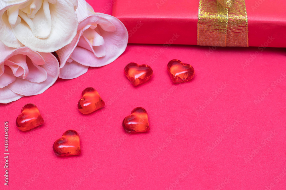 Congratulations on Valentine's Day: roses, a gift box and hearts on a red background, copy space. The photo Congratulations on Valentine's Day: roses, a gift box and hearts on a red background, copy space. The photo
