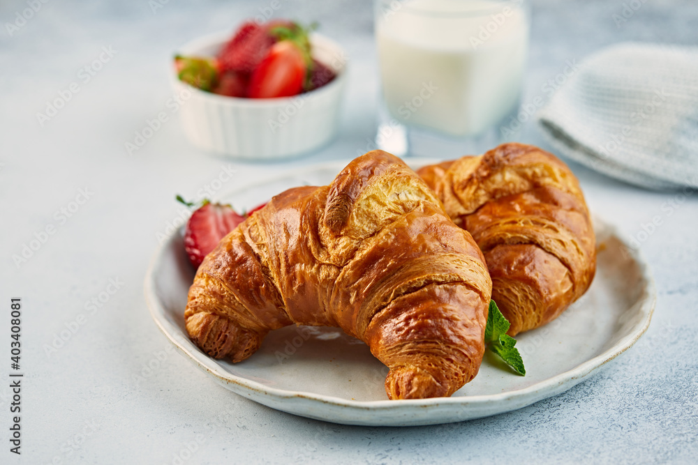 Croissant on a plate with strawberries and glass of fresh milk Croissant on a plate with strawberries and glass of fresh milk