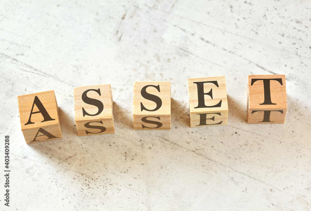 Five wooden cubes with word ASSET on white stone like board, view from above Five wooden cubes with word ASSET on white stone like board, view from above