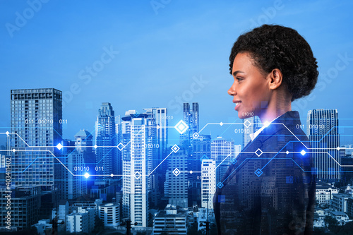 Attractive black businesswoman pondering on technology at business process to achieve tremendous growth in commerce. Tech hologram icons over Bangkok background