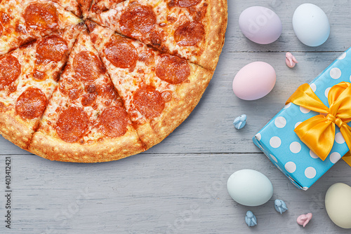 easter eggs and gift box with beautiful bow on wooden gray background