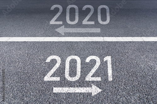 The sign arrow back to the 2020 year and go ahead 2021 Written on The asphalt road background The vision new year of 2021.