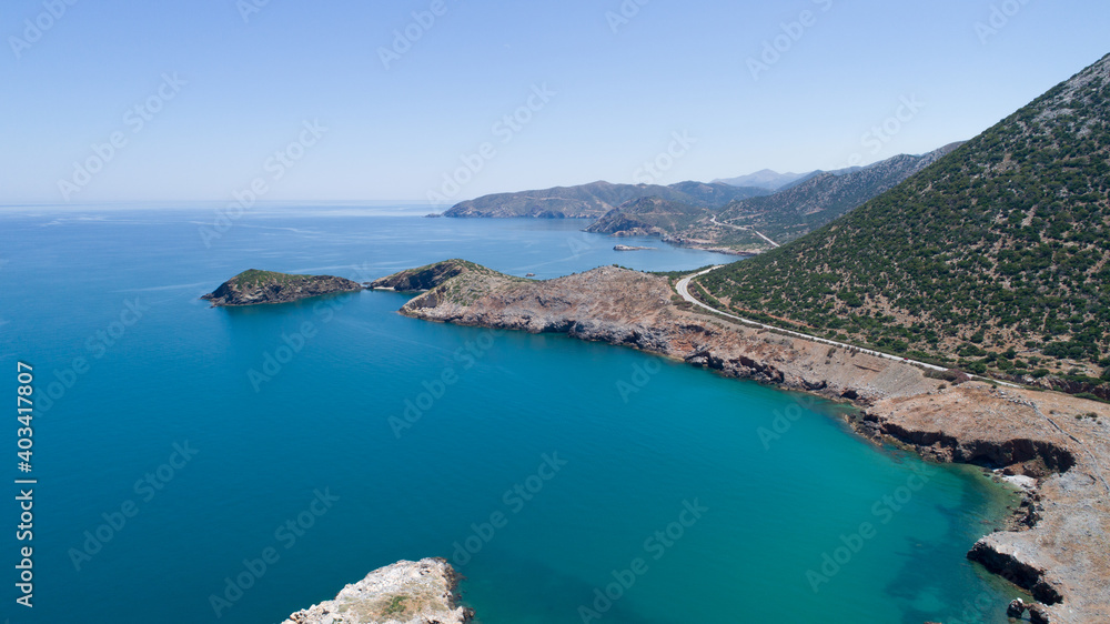 Beautiful landscape of the island from a bird's-eye view. Blue sea, clear sky, rocks, road, cliff and green mountains.