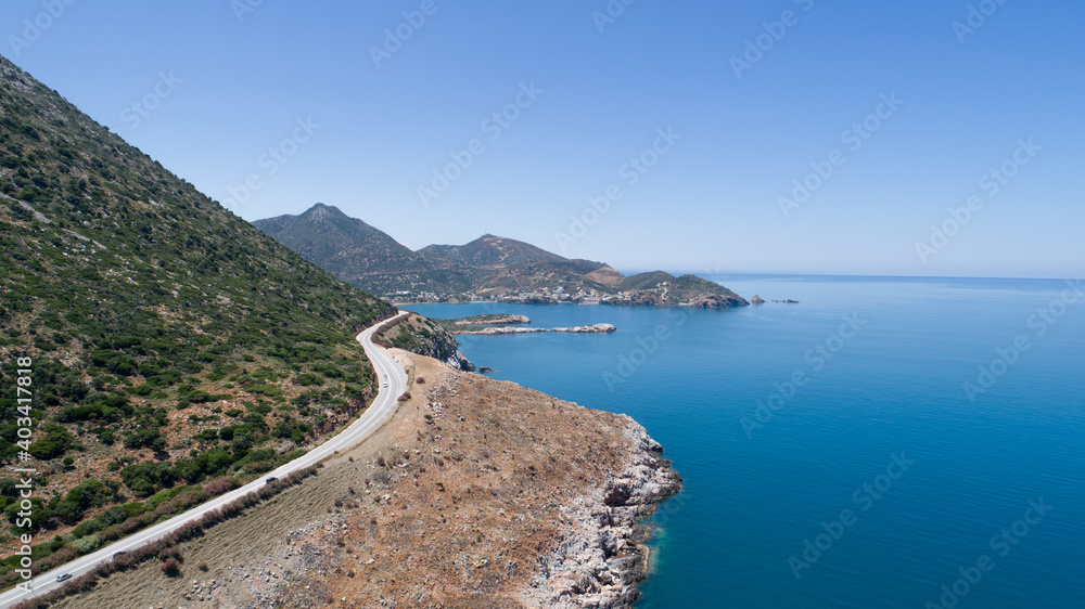 Beautiful landscape of the island from a bird's-eye view. Blue sea, sky, rocks, road, cliff and green mountains. Beautiful landscape of the island from a bird's-eye view. Blue sea, sky, rocks, road, cliff and green mountains.