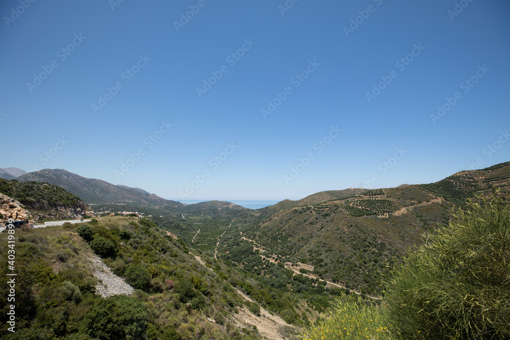 A view of the island is green mountains and plantations of olive trees.