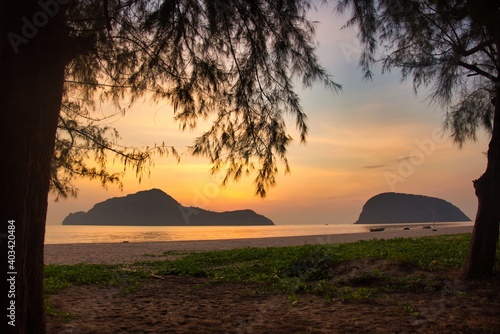 sunrise behind mountain at beach with coloful sky in Thailand