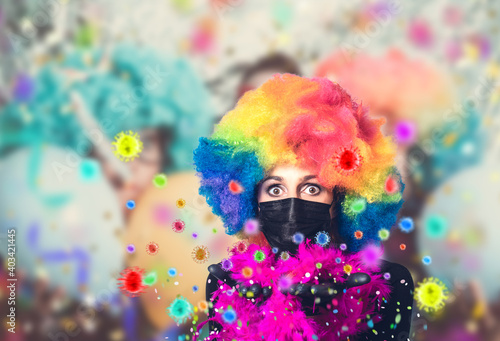 Fototapeta Naklejka Na Ścianę i Meble -   young pretty woman with carnival costume and wig blows corona virus as confetti into the crowd