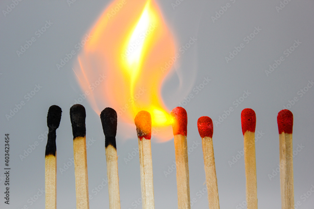 matches lighting in a line as a chain reaction with burnt and new red matches and orange exploding flame matches lighting in a line as a chain reaction with burnt and new red matches and orange exploding flame