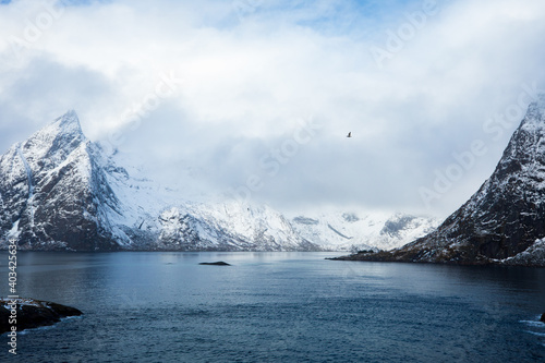 Beautiful landscape. Lofoten Islands. Sea against the backdrop of white mountains and clouds.