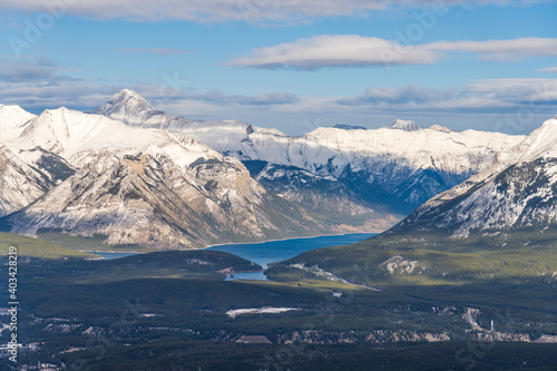 Overlook view Lake Minnewanka and surrounding snow-covered Canadian Rocky Mountains in early winter time. Banff National Park, Alberta, Canada.