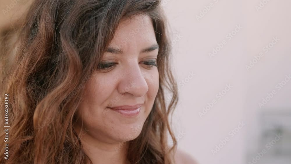 Woman with long brown hair looking down and smiling Woman with long brown hair looking down and smiling