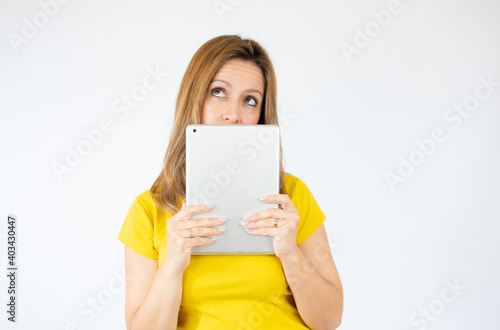 intelligent young woman holding a tablet over white background