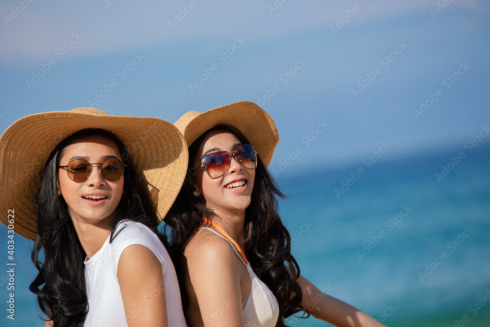 Two happy women are sitting on the beach While relaxing on vacation for the weekend on sunny days and nice weather in travel and holiday concept.