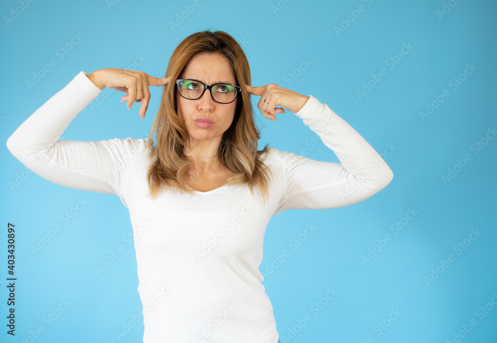 young pretty woman thinking, feeling doubtful and confused, with different options, wondering which decision to make against blue wall young pretty woman thinking, feeling doubtful and confused, with different options, wondering which decision to make against blue wall
