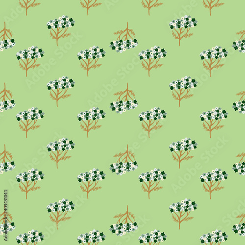 Little abstract blue and brown colored yarrow ornament seamless pattern on light green background. © Lidok_L