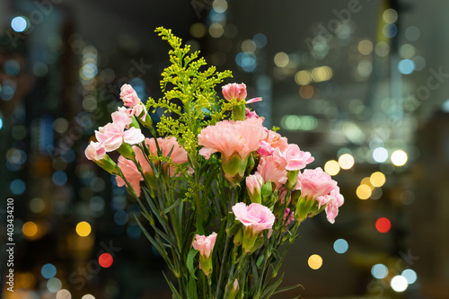 bouquet of carnation flowers with twinkling blurred city night lights. romantic concept for lovers and valentine © James Jiao
