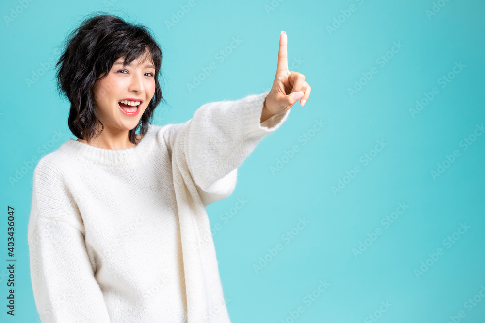 Young woman showing her index finger portrait isolated on blue background Young woman showing her index finger portrait isolated on blue background