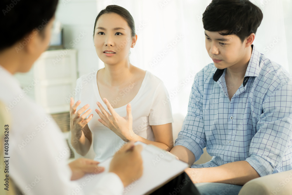 Fototapeta premium Young couple talking to doctor during counseling session regarding their relationship