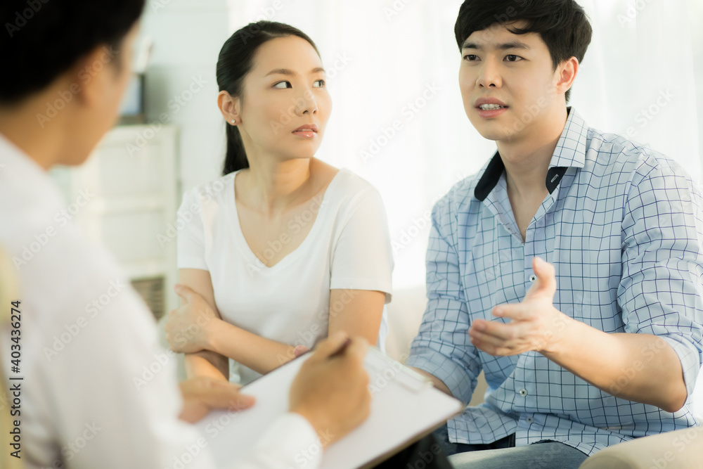 Young couple talking to doctor during counseling session regarding their relationship Young couple talking to doctor during counseling session regarding their relationship