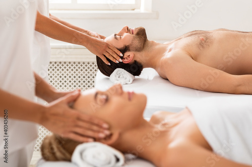 Relaxed Couple Receiving Head Massage Lying In Beauty Salon