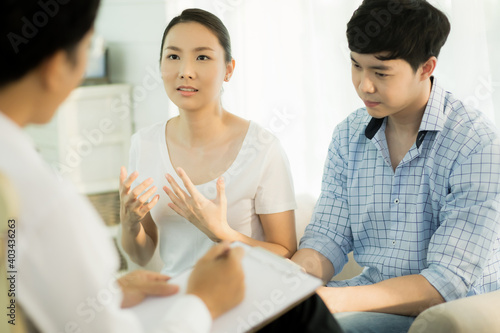 Young couple talking to doctor during counseling session regarding their relationship