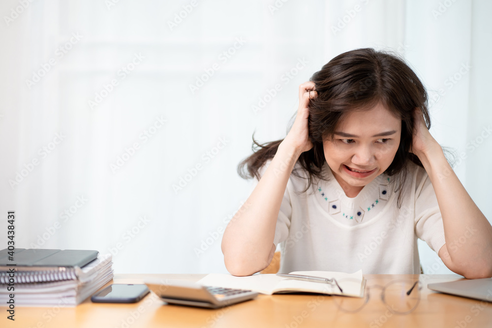 Stressful and upset Asian young businesswoman catching at her head. Stressful and upset Asian young businesswoman catching at her head.