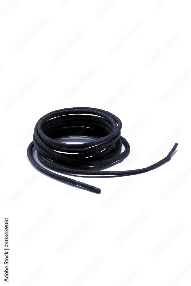 Subject shot of navy blue shoe strings with thin tips. The shoe laces are rolled into a coil and isolated on the white background. Subject shot of navy blue shoe strings with thin tips. The shoe laces are rolled into a coil and isolated on the white background.