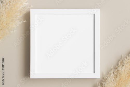 Top view of a white square frame mockup with pampas decoration.