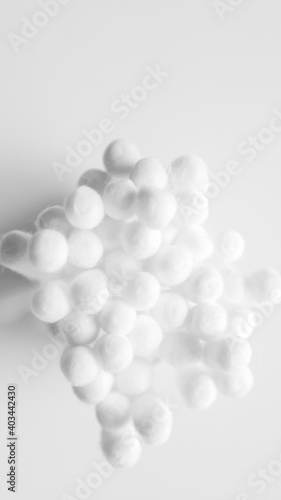 Close-up photo of white cotton swabs and white cotton swabs on isolated white background.