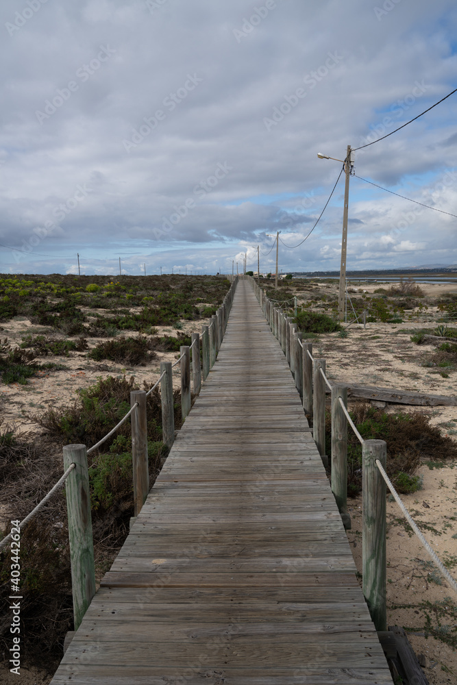 endless long wooden boardwalk in the Ria Formosa National Park on the Algarve